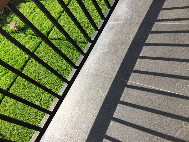 metal fence shadow balcony with view grassy field sunny day 181624 2835